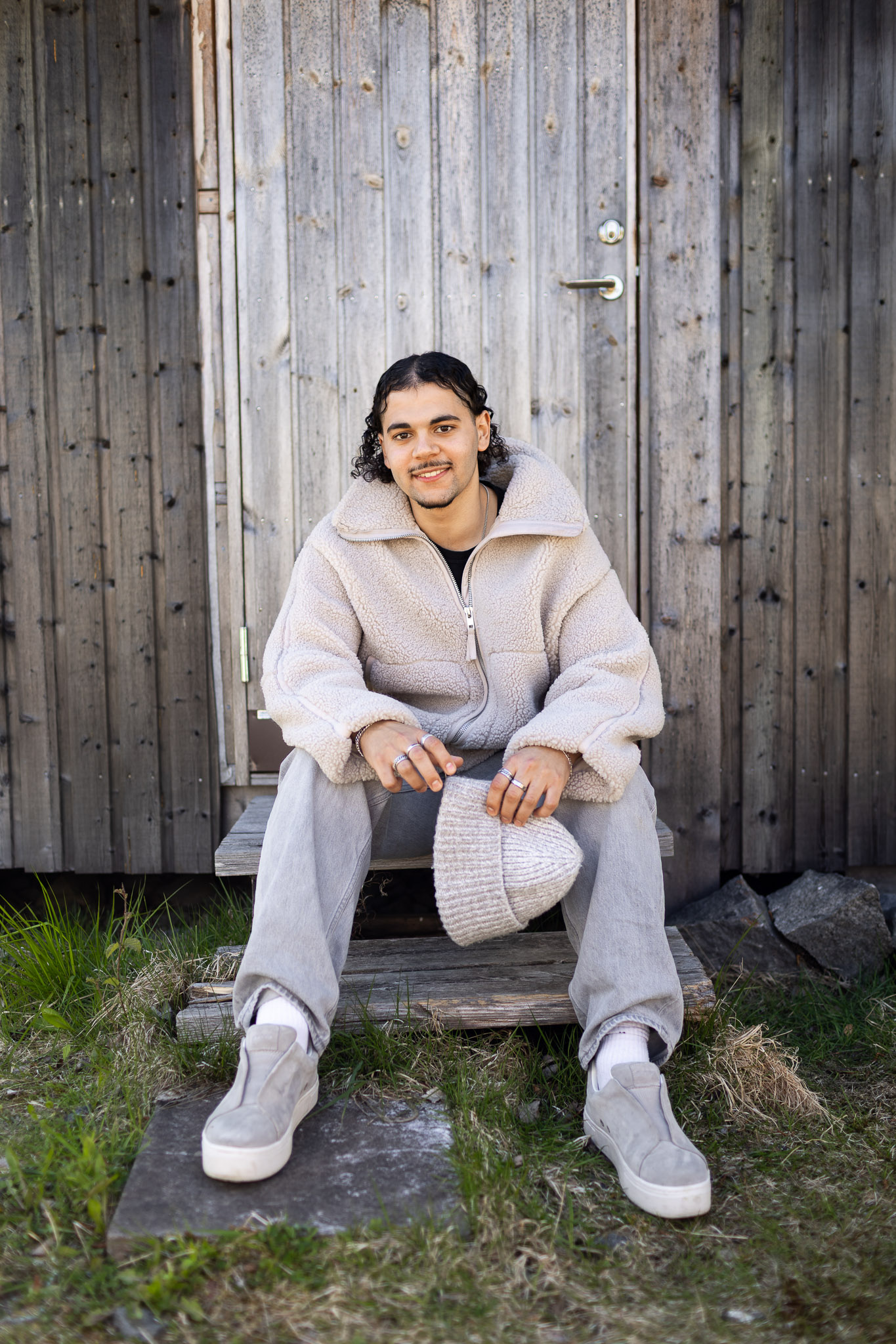 En ung man sitter på en liten trappa